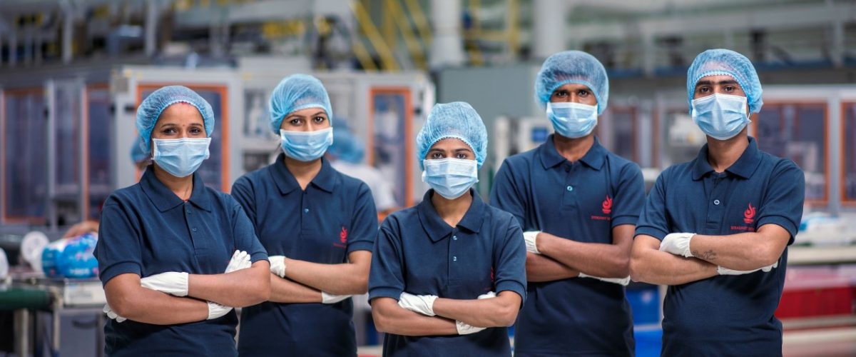 Swara Baby Group production team in blue uniforms, hairnets and masks